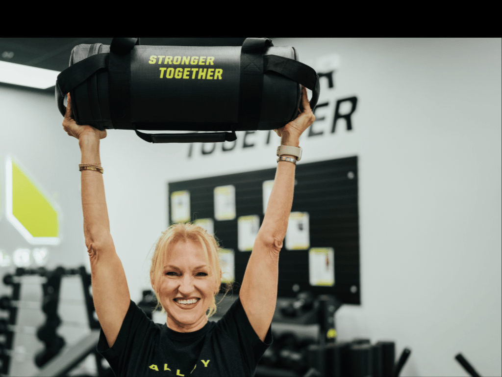 2-alloy-personal-training-female-client-holding-weight-bag